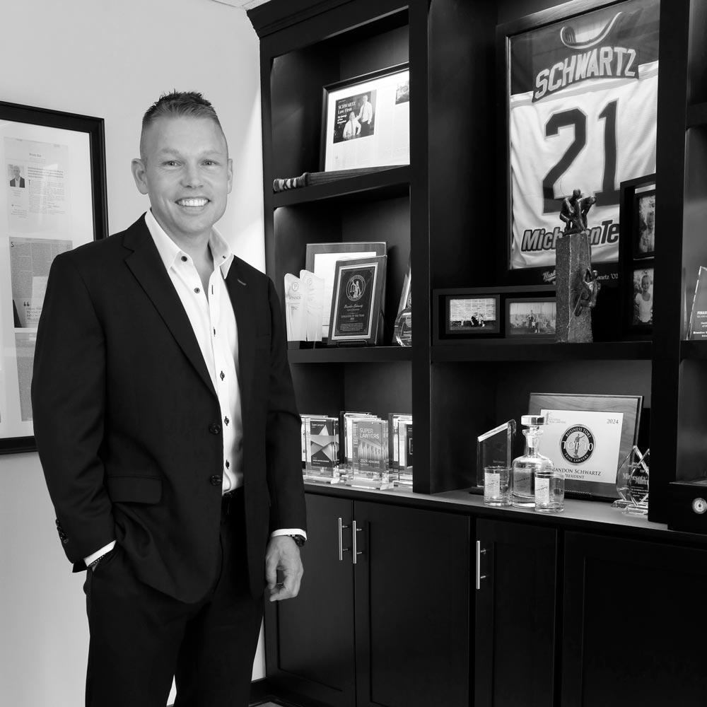 Brandon M. Schwartz standing next to trophy case